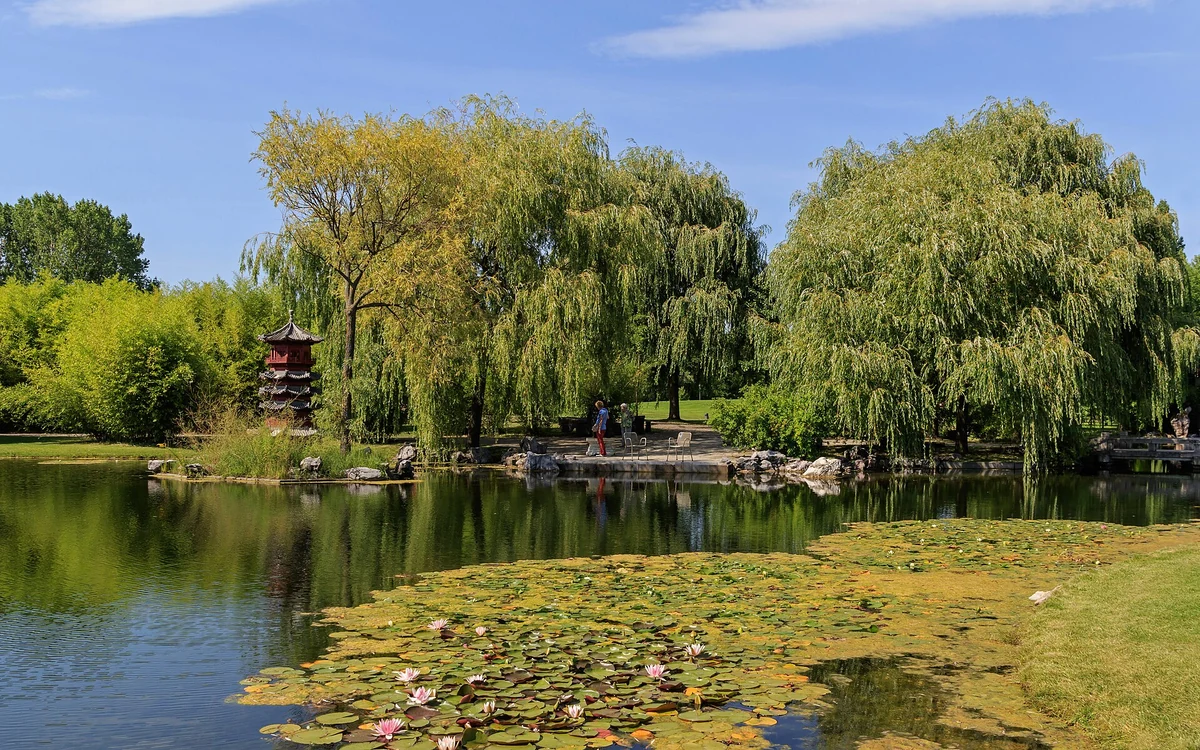 Chinesischer Garten in den Gärten der Welt – rote Pagode und Teich mit Seerosen im Garten des wiedergewonnenen Mondes, Berlin-Marzahn