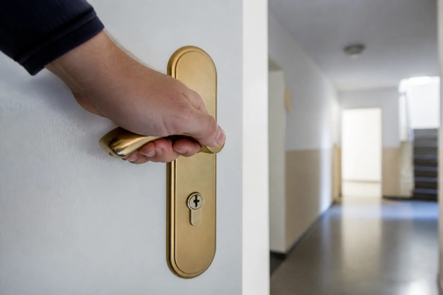 Hand an der Messing-Türklinke mit Profilzylinder — Wohnungstür in Trebbin
